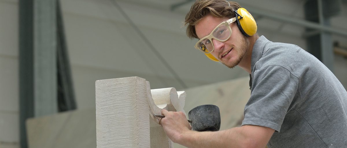 München, DEU, 12.05.2014 Steinmetz der Firma Steininger. Schlagwort(e): Werkstatt, Steinmetz formt Stein, Hammer, seitliche Positionieru