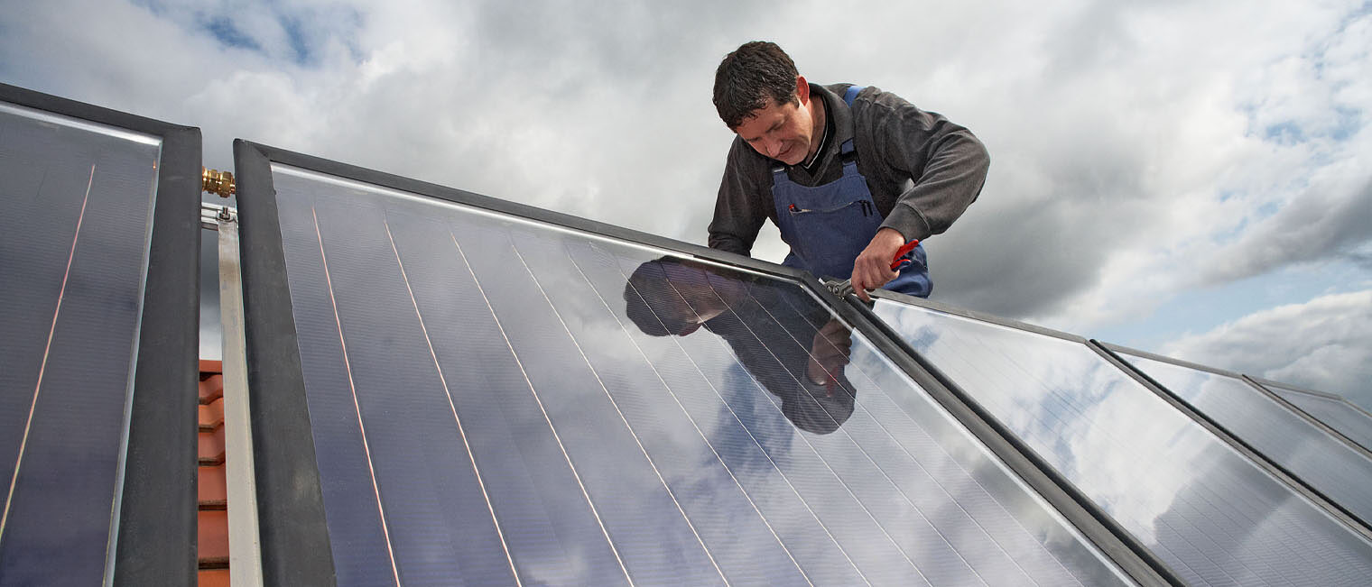 Handwerker aus Dach montiert Photovoltaik-Module