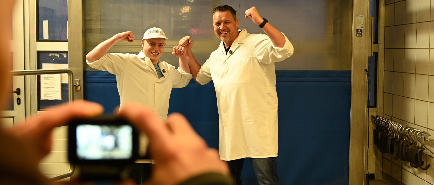 Zwei Personen machen eine Siegerpose vor der Kamera