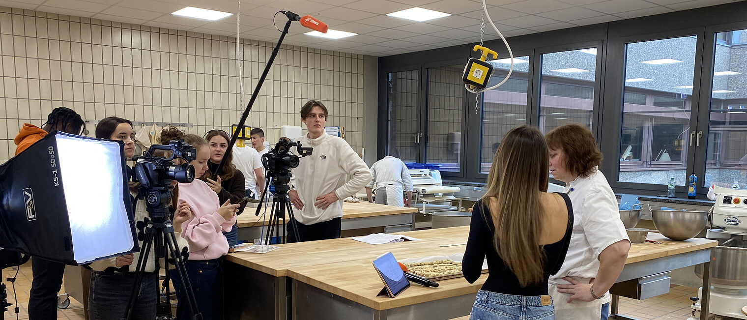 Gruppe von Studierenden mit Kameras und Mikrofon in der Backstube Gruppe von Studierenden mit Kameras und Mikrofon in der Backstube des Bildungszentrum bei einem Videodreh
