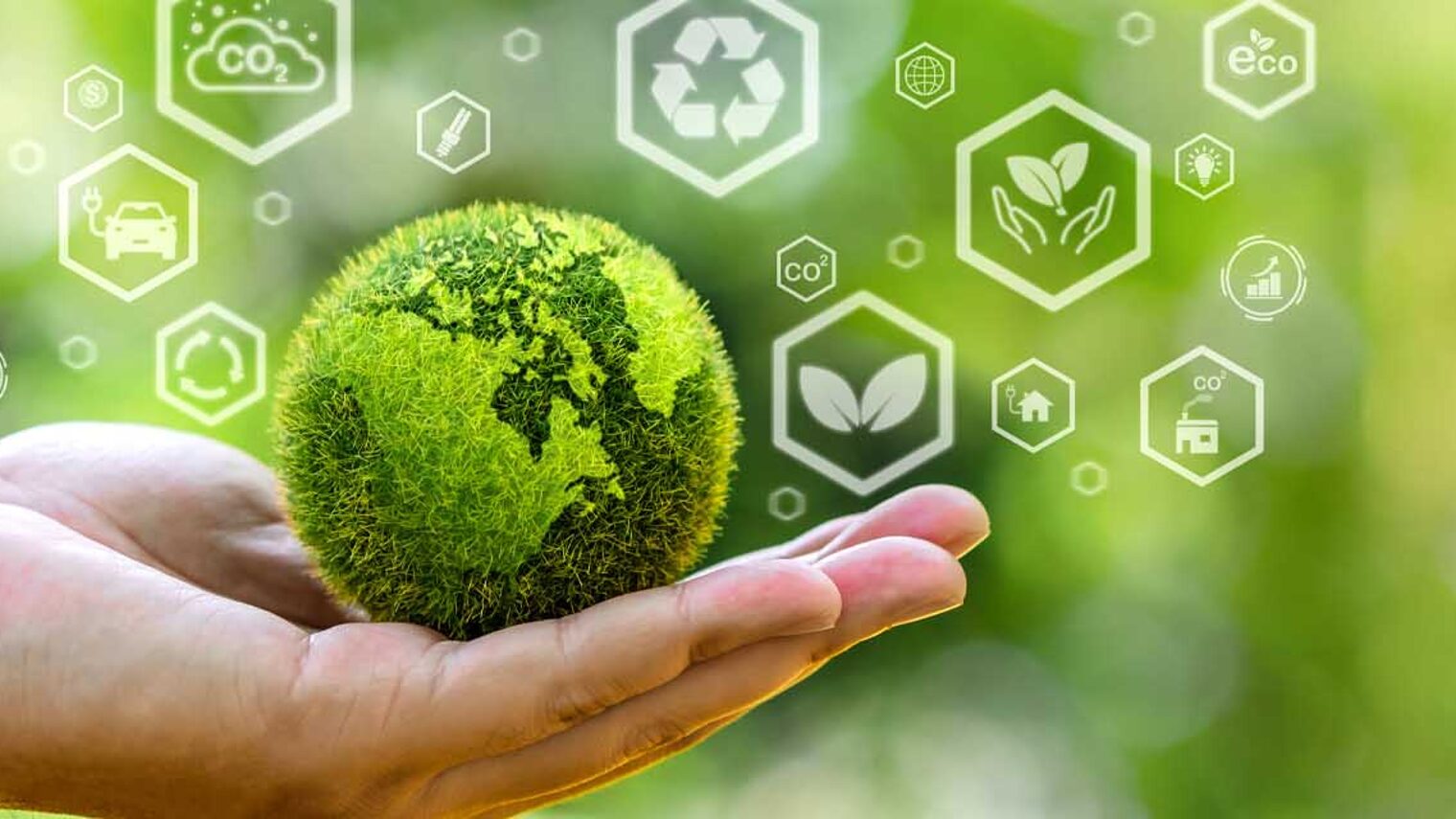 Symbolfoto für Nachhaltigkeit Hand hält grüne Erde in Miniatur