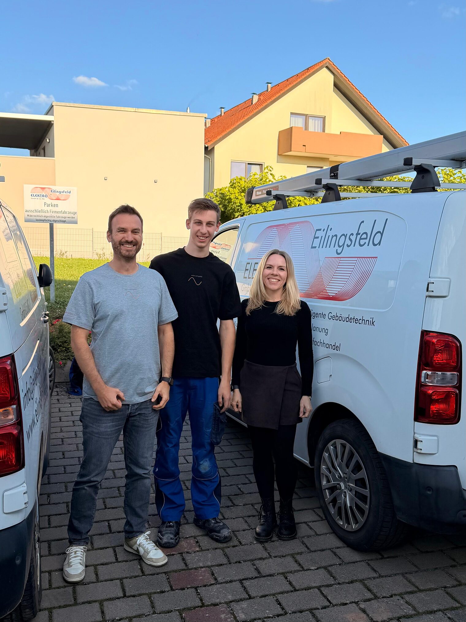 Gruppenfoto Elektroniker mit zwei Kollegen vor Auto
