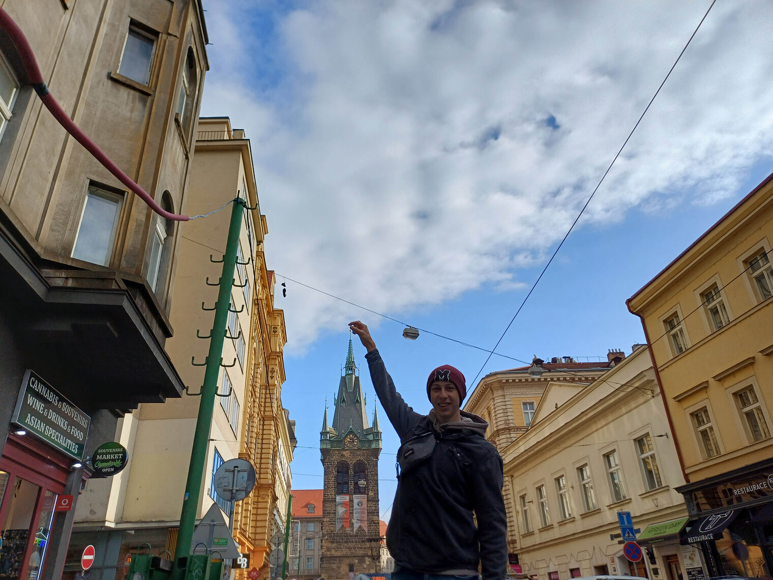 Elektroniker in Innenstadt zeigt mit Hand auf Kirchturm