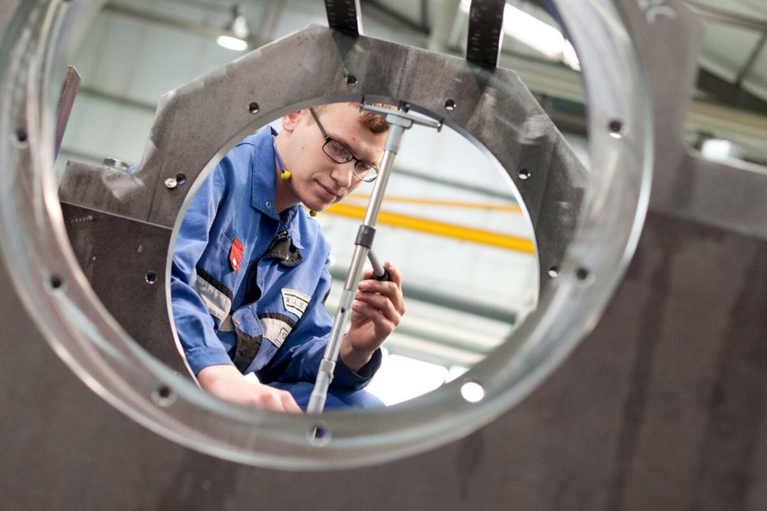 Metallbauer in Schutzkleidung richtet ein Stab aus