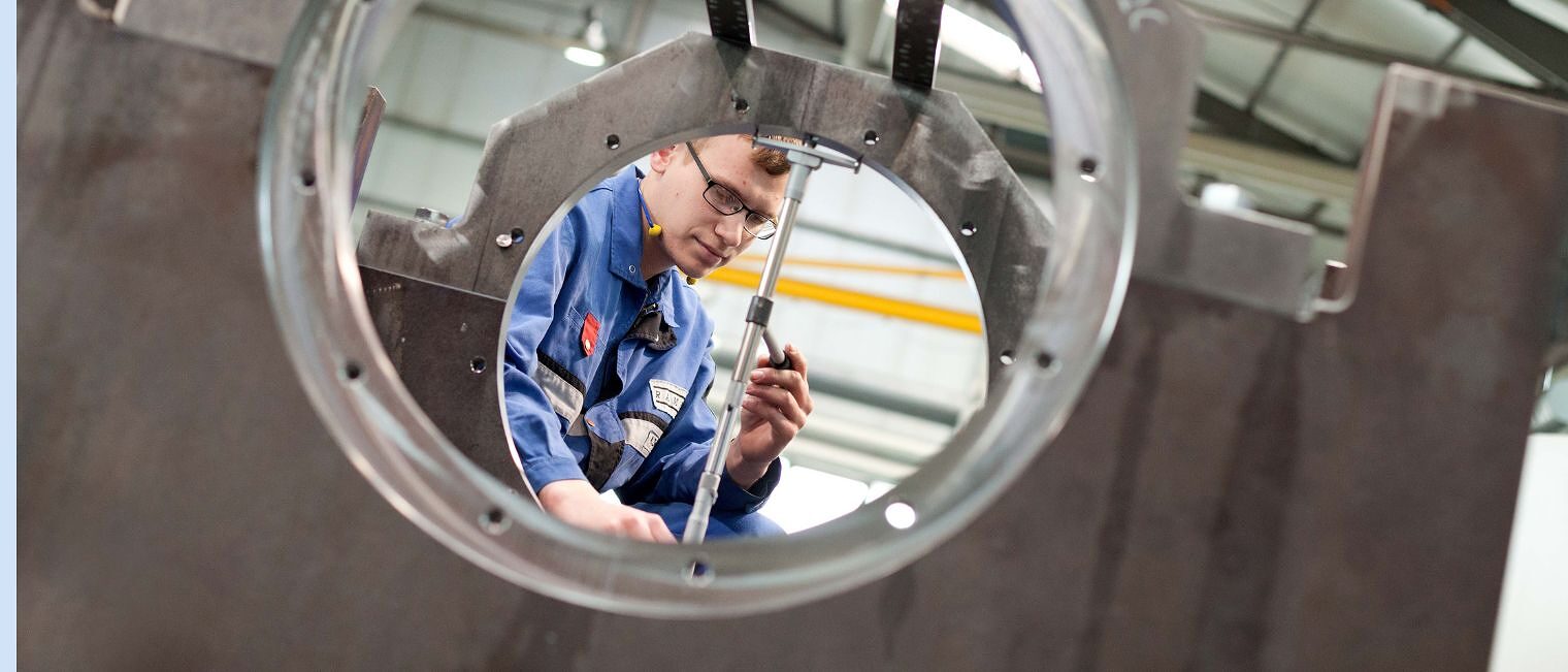 Metallbauer in Schutzkleidung richtet ein Stab aus