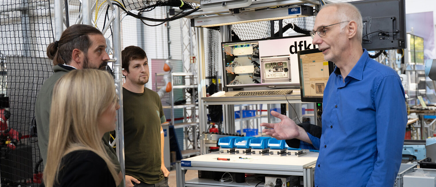 Labor mit Computer und Tracking-Ki-Aufbau, eine Person erklärt drei anderen etwas