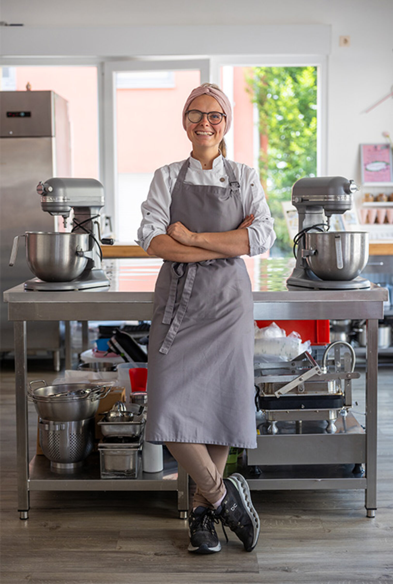 Die Dozentin Franziska Weiler steht lächelnd vor einem Gestell mit Backutensilien.