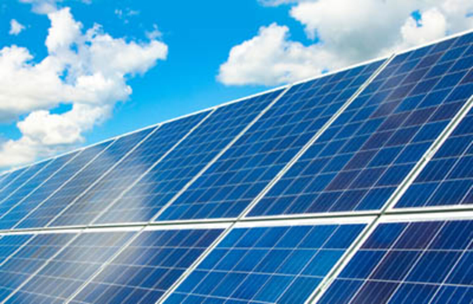Solar-Panele mit blauen HImmel und sommerlich weißen WOlken im Hintergrund