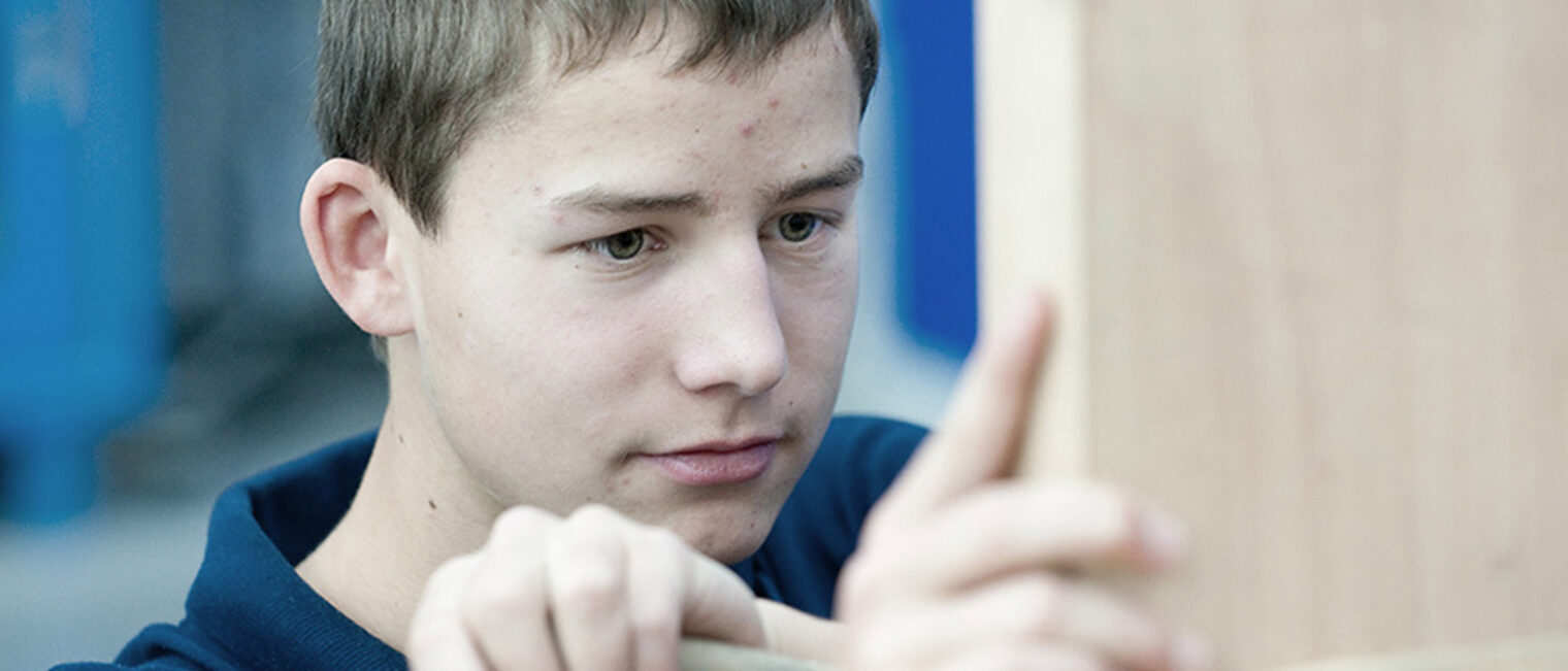 Überbetriebliche Lehrlingsunterweisung Nahaufnahme von Schüler in einer Werkstatt